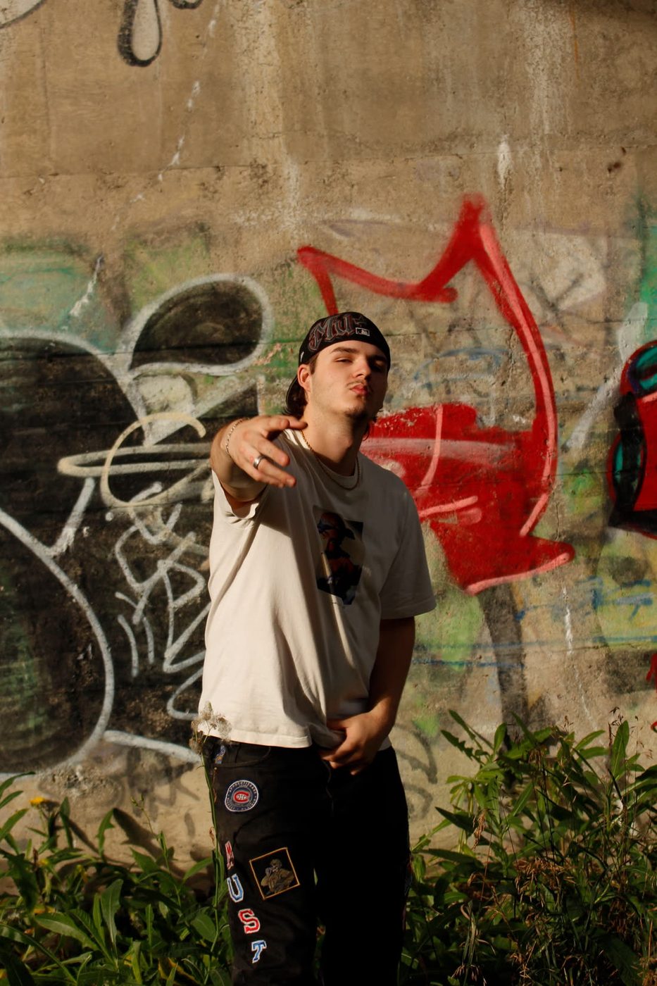 Must devant un mur de graffitis
